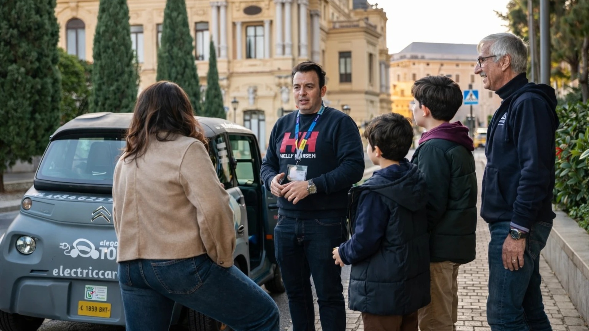 Guía explica tour a las cuevas del tesoro en coche eléctrico a una familia en Málaga, España.