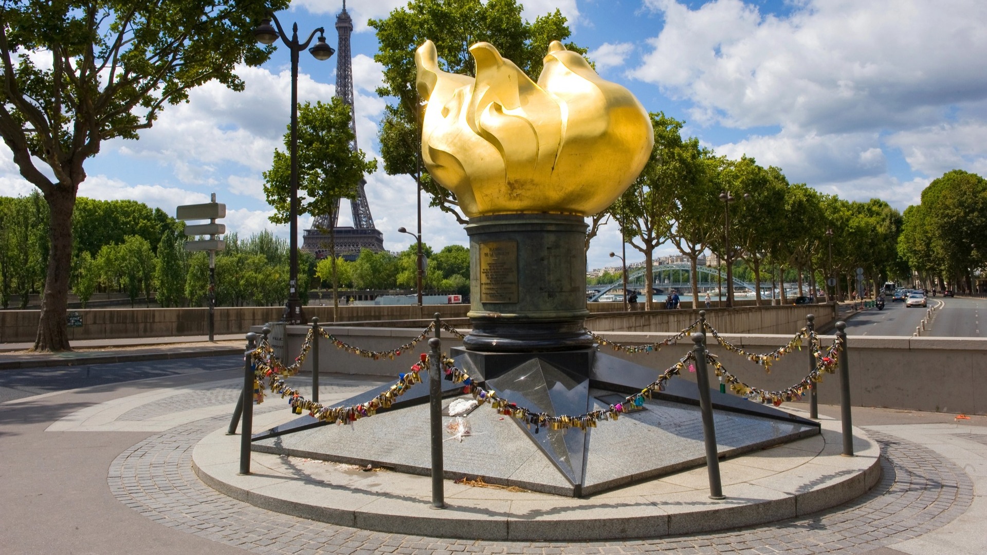Llama de la Libertad con candados y la Torre Eiffel al fondo en París