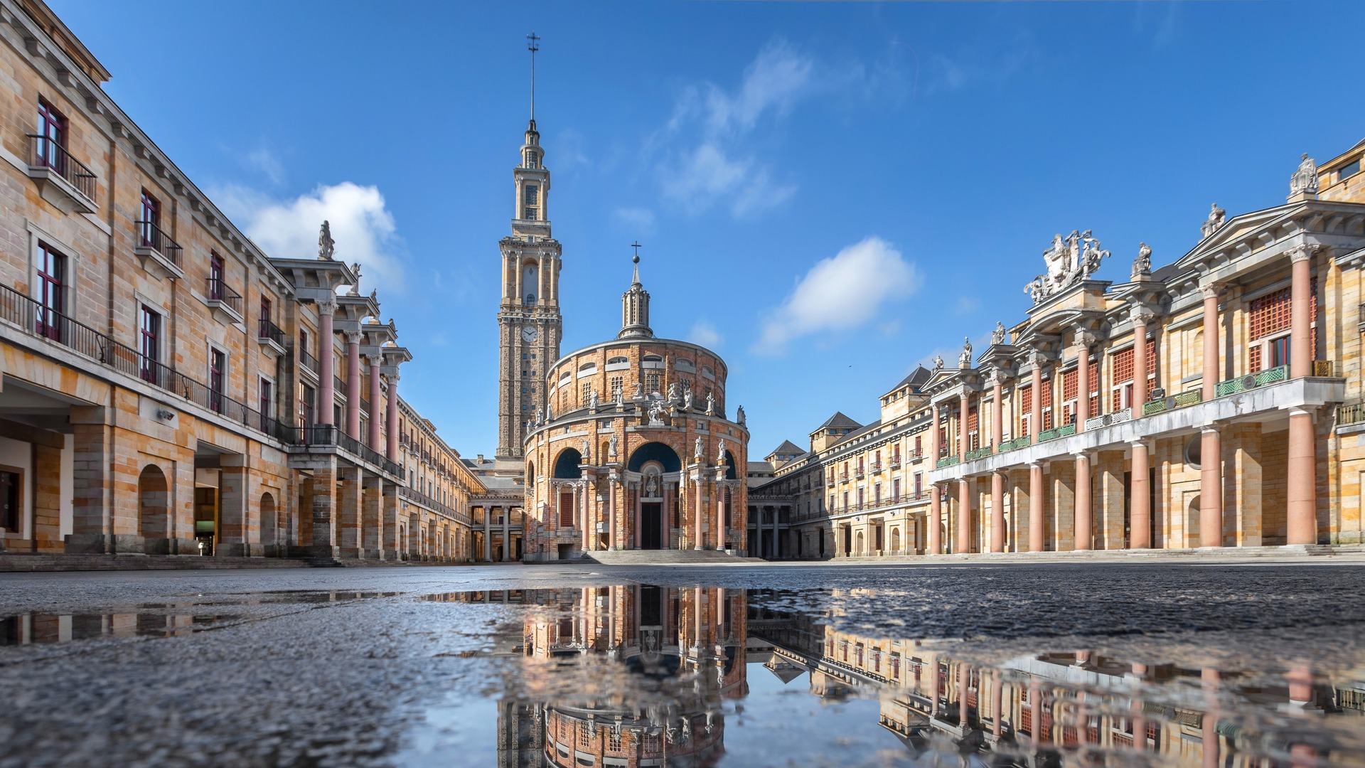 Reflejo de la Universidad Laboral de Gijón en un charco.