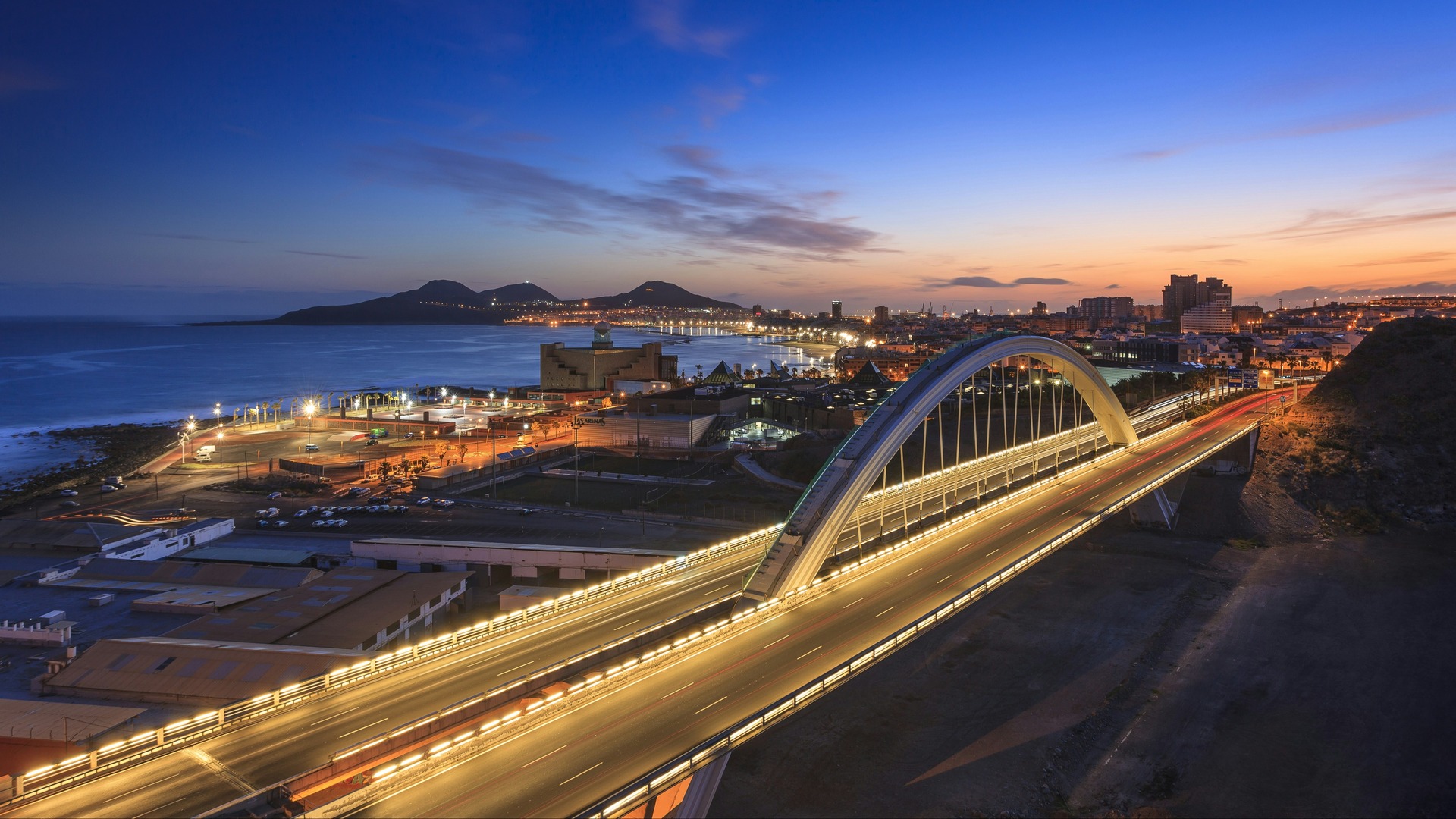Puente de El Rincón iluminado al anochecer frente a la costa de Las Palmas.