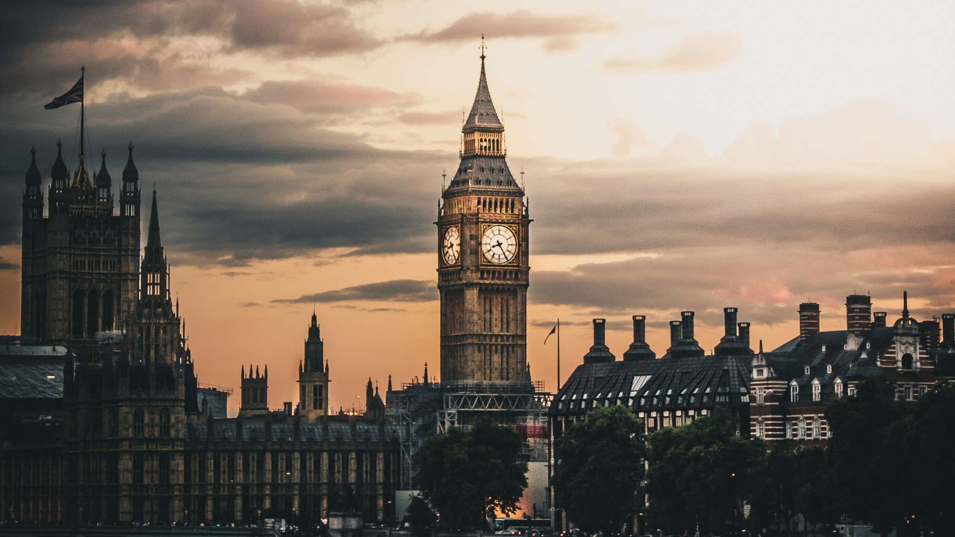 Torre del Big Ben y Palacio de Westminster bajo un cielo nublado al atardecer.