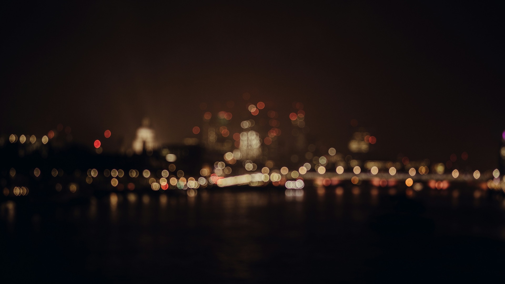 Luces de la ciudad de Londres desenfocadas sobre el Támesis.
