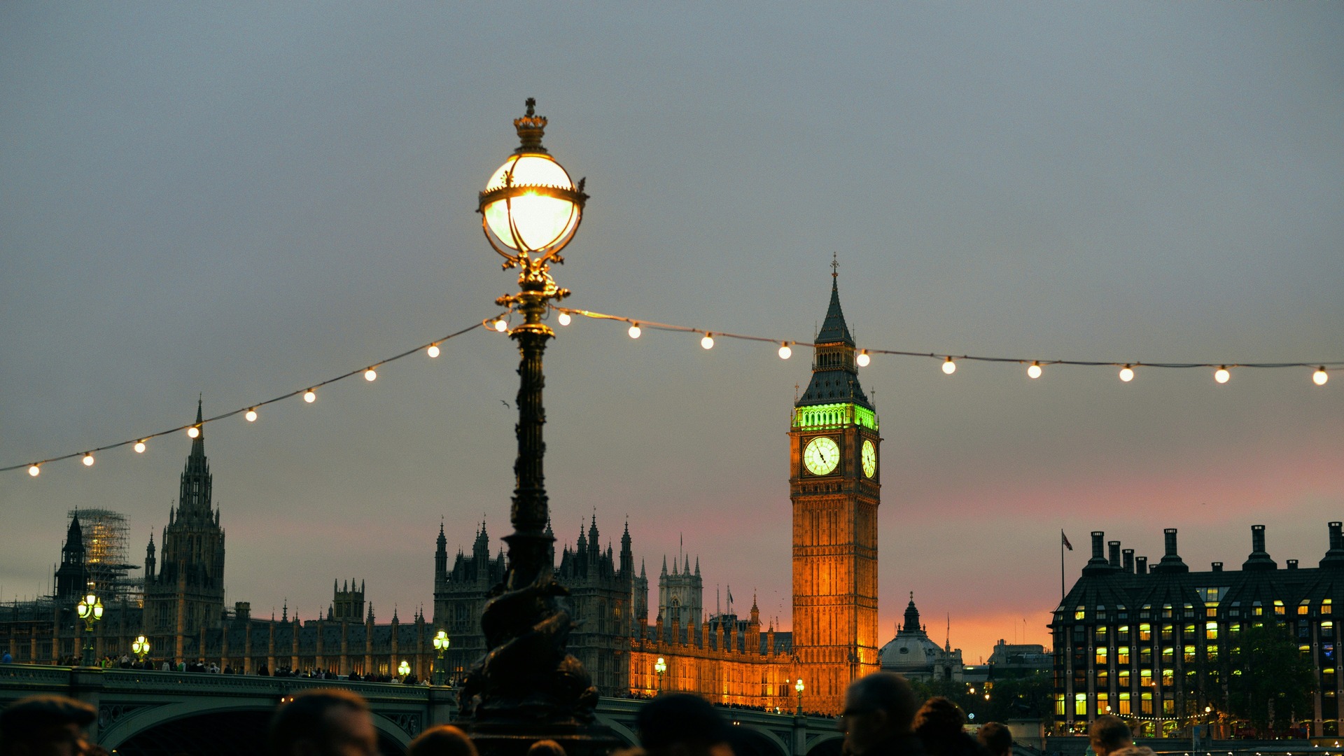 Big Ben iluminado tras farolas y guirnaldas de luces junto al Támesis.