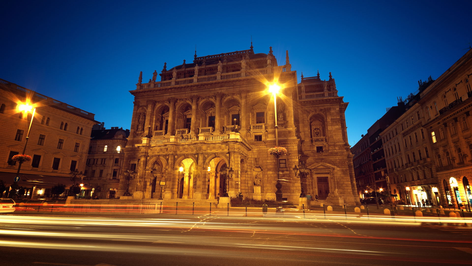 La iluminada Ópera Estatal de Hungría en Budapest de noche, con estelas de luz.