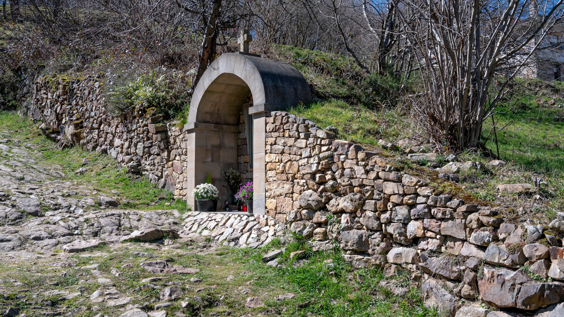 Pequeña capilla o altar de piedra en San Sebastián de Garabandal, Cantabria, situada junto al camino empedrado
