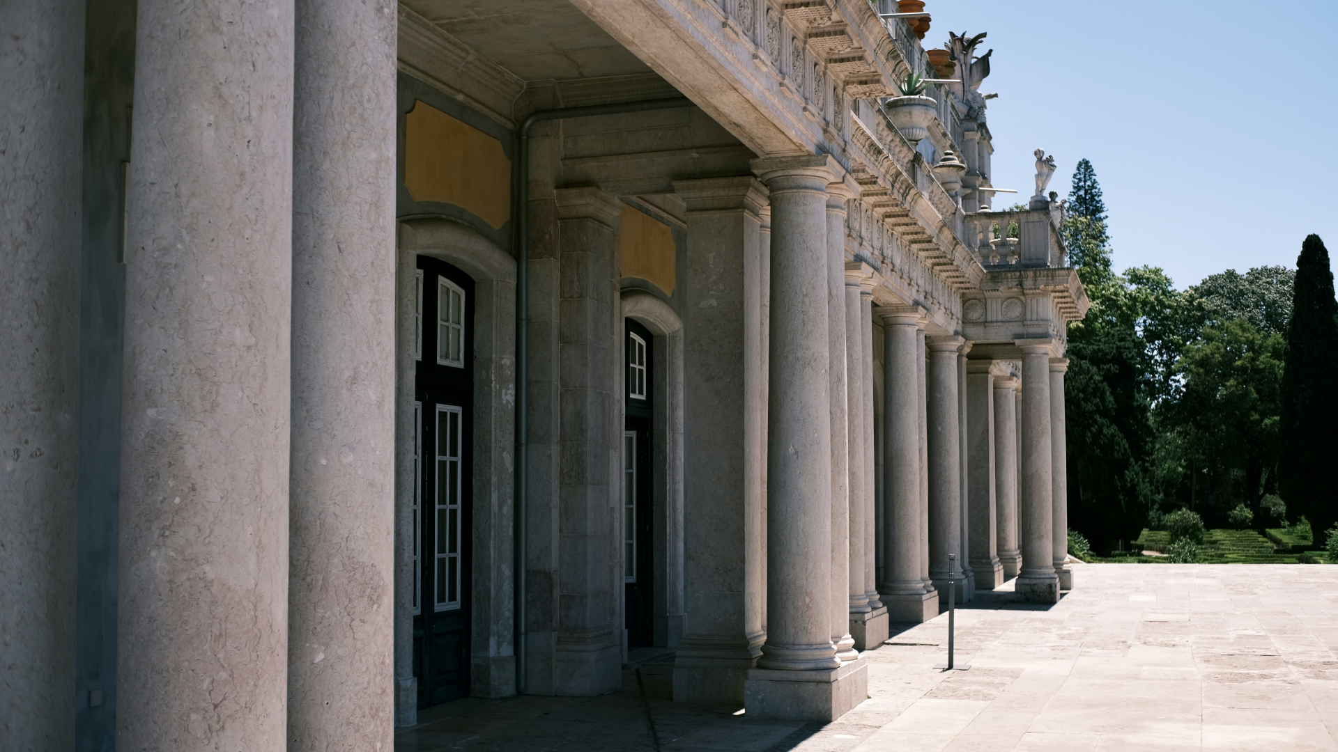 Columnata del Palacio de Queluz con columnas clásicas y jardín, Portugal