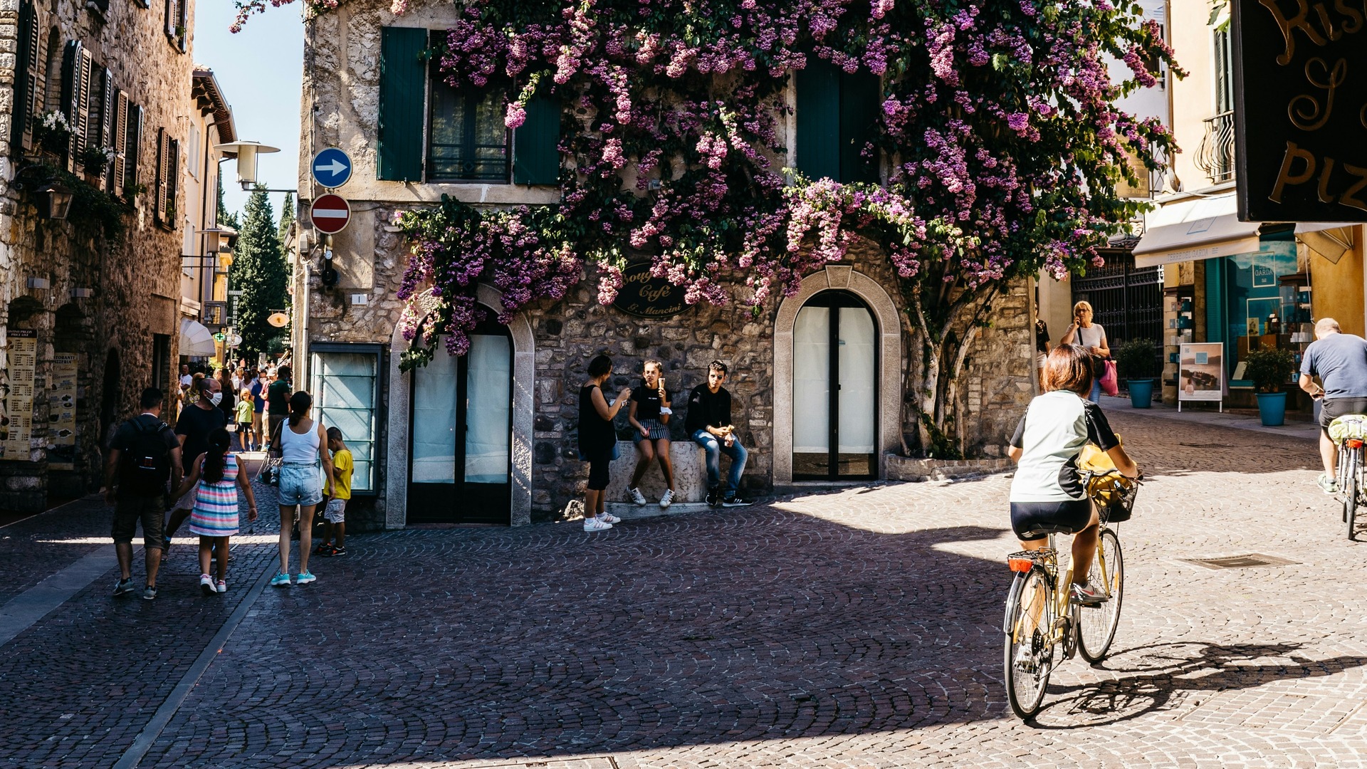 Calle peatonal con fachadas floridas en el centro histórico de Sirmione, Italia