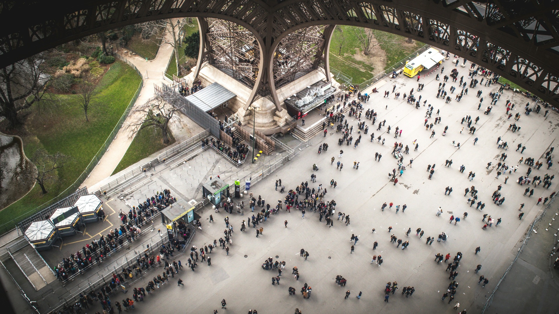 Explanada bajo la Torre Eiffel con visitantes en París, Francia