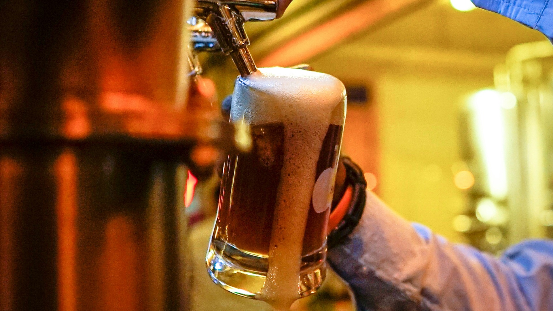 Cerveza artesanal con espuma desbordando el vaso tirada de un grifo en Berlín.