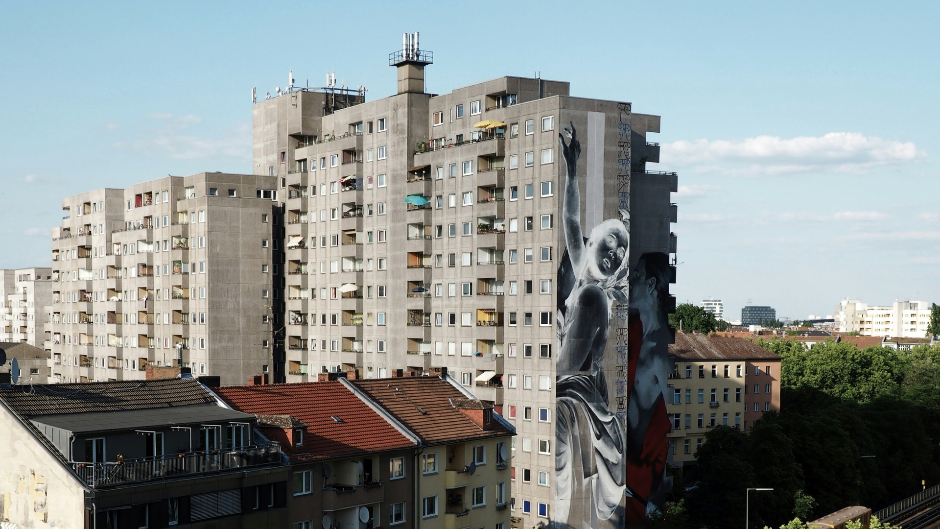 Edificio de apartamentos en Berlín con gran mural artístico en la fachada lateral.