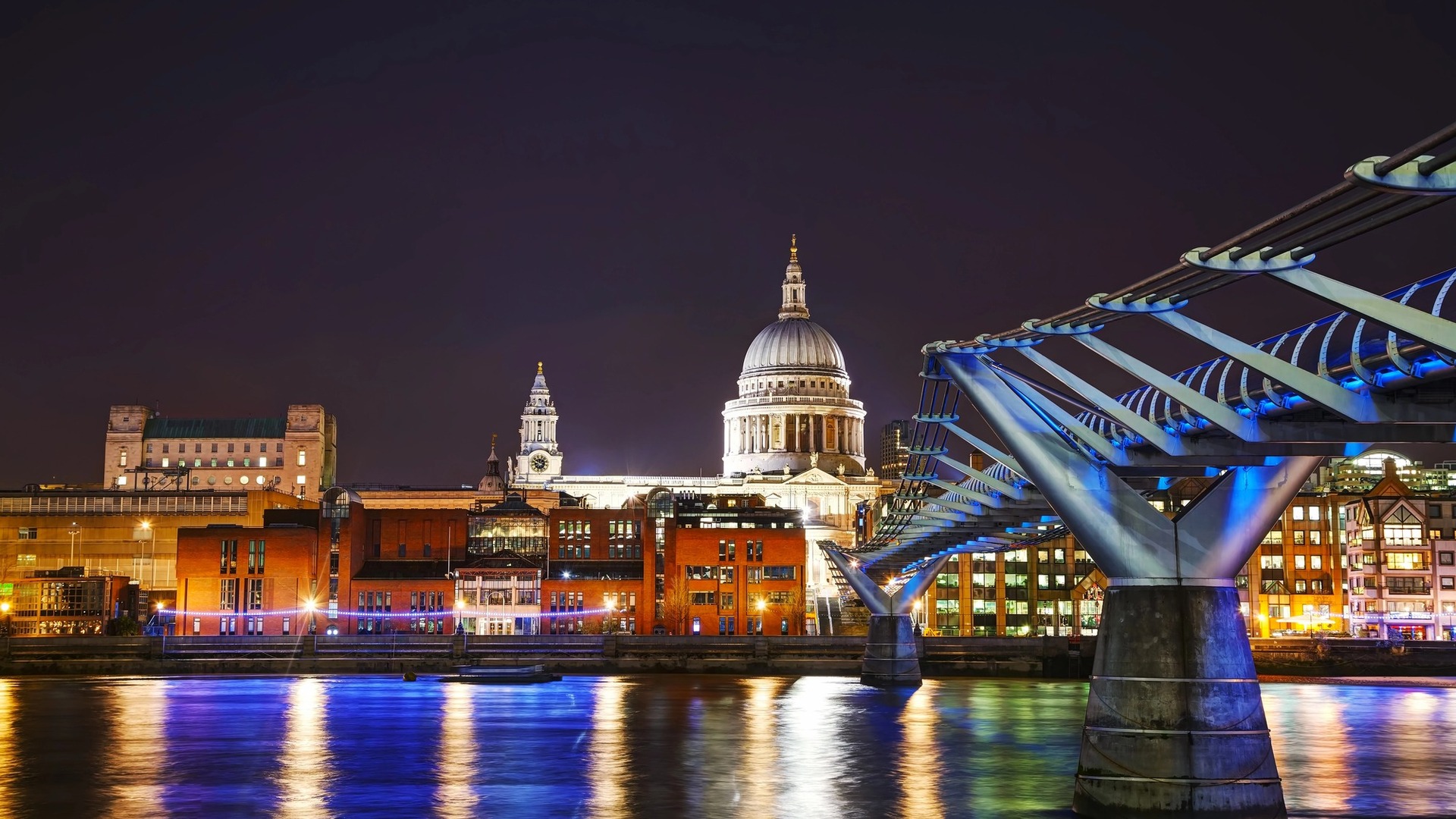 Catedral de San Pablo y Millennium Bridge iluminados de noche en Londres.