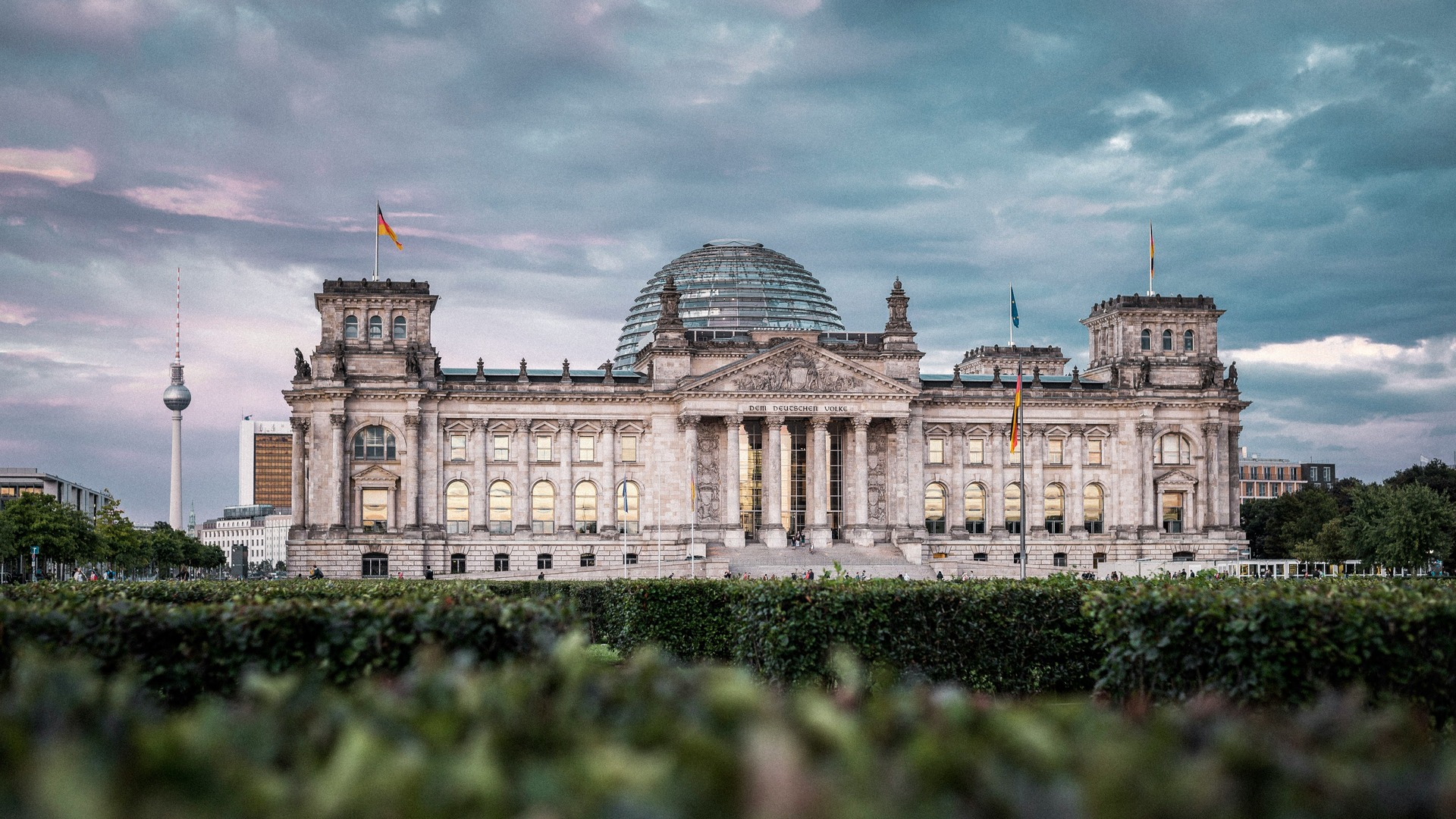 Edificio del Reichstag con cúpula de cristal bajo un cielo nublado en Berlín.