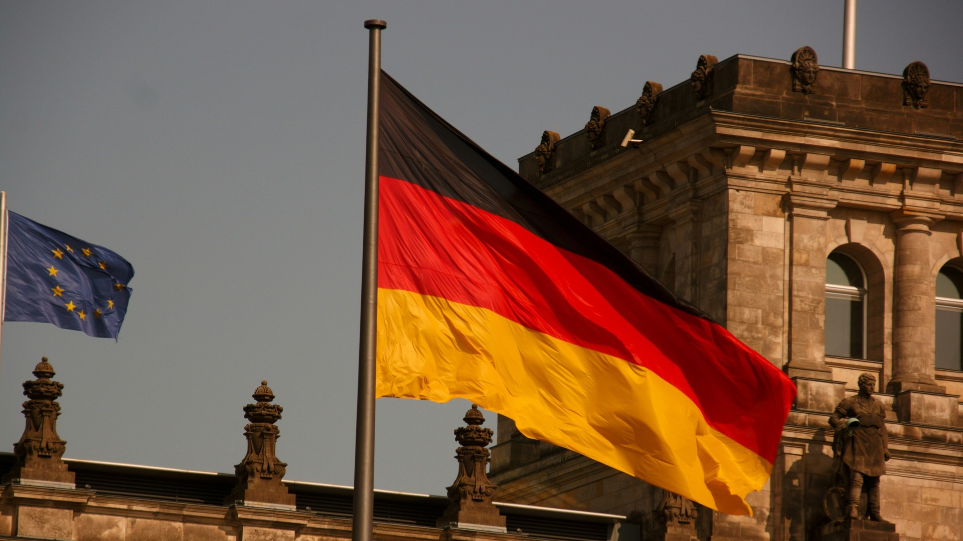 Bandera de Alemania y de la Unión Europea frente al edificio del Reichstag.