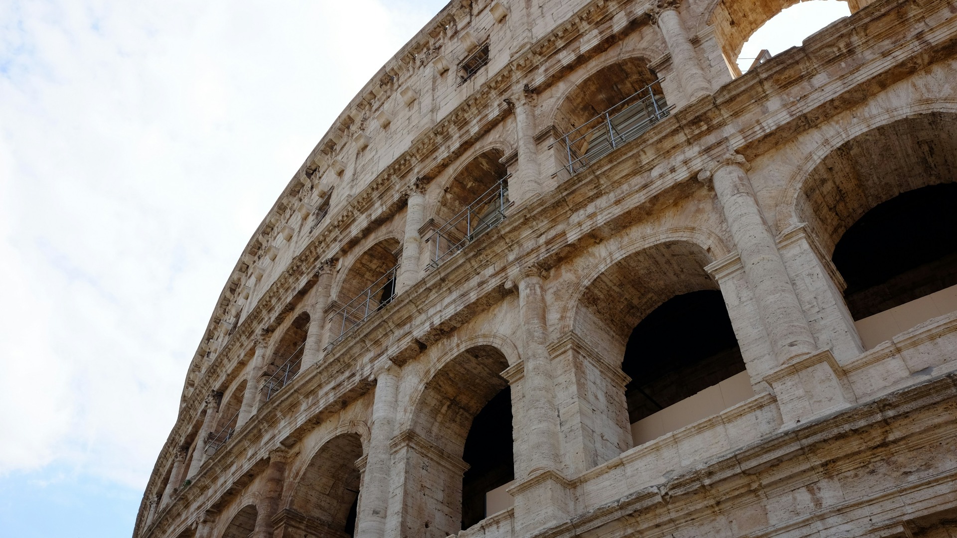 Primer plano de los arcos de piedra del Coliseo Romano