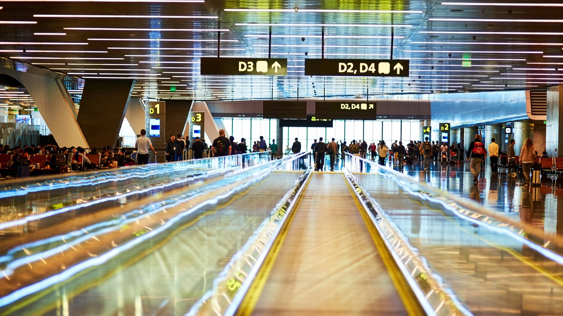 Pasajeros en pasarela mecánica del Aeropuerto de Asturias