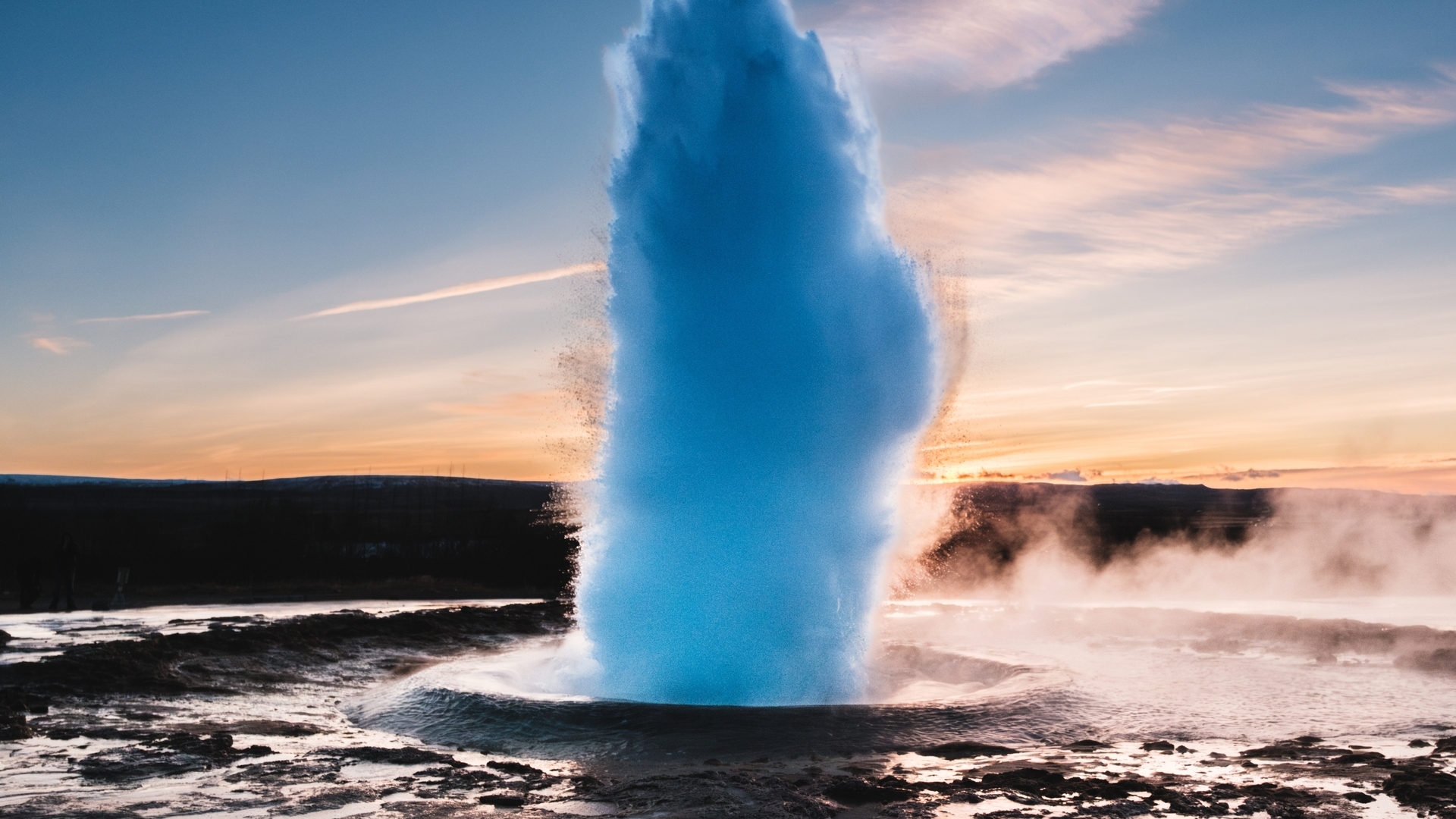 Erupción del géiser Strokkur en el valle de Haukadalur, Islandia, al atardecer entre vapor y aguas termales.