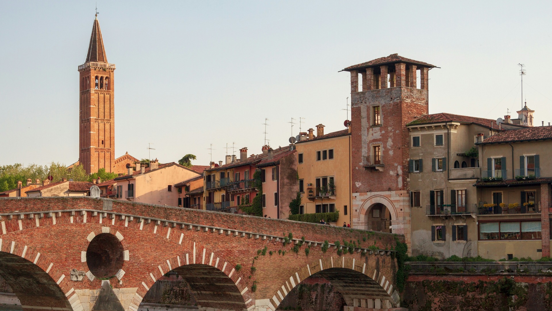 Puente Castelvecchio y casas históricas junto al río Adigio en Verona, Italia