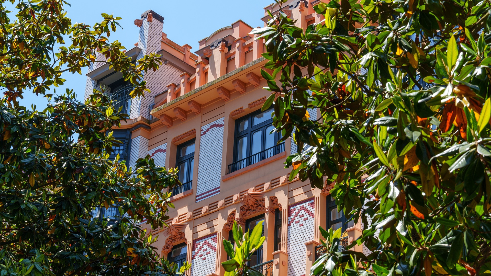 Edificio modernista entre árboles en el centro de Gijón