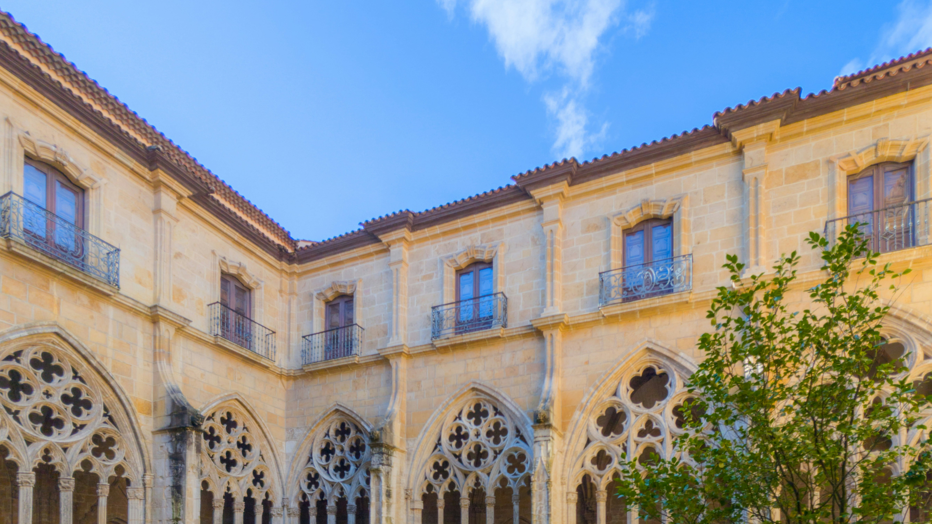 Galería del claustro con arcos góticos durante visita guiada en Oviedo