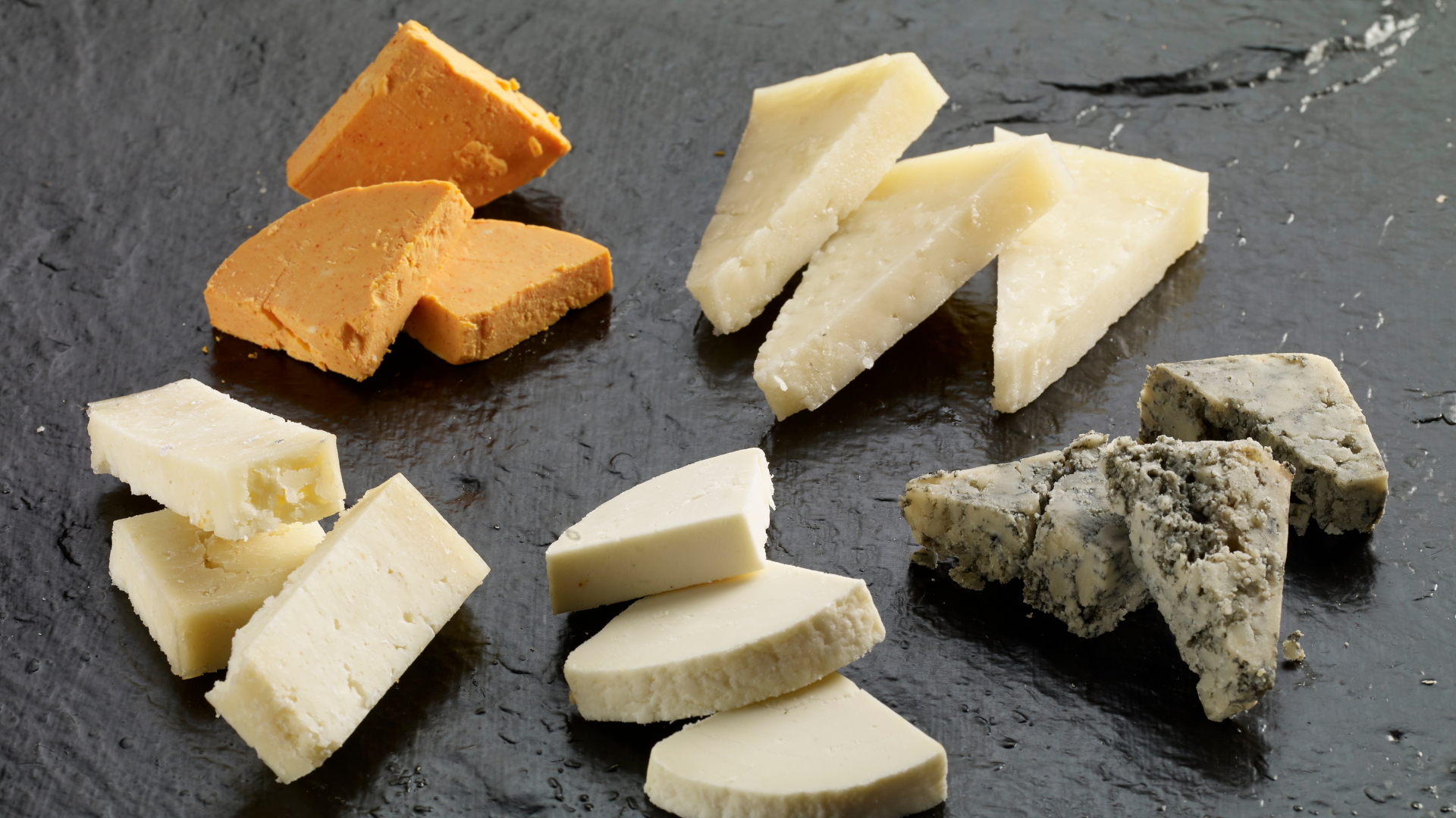 Selección de quesos asturianos en pizarra durante visita guiada en Oviedo