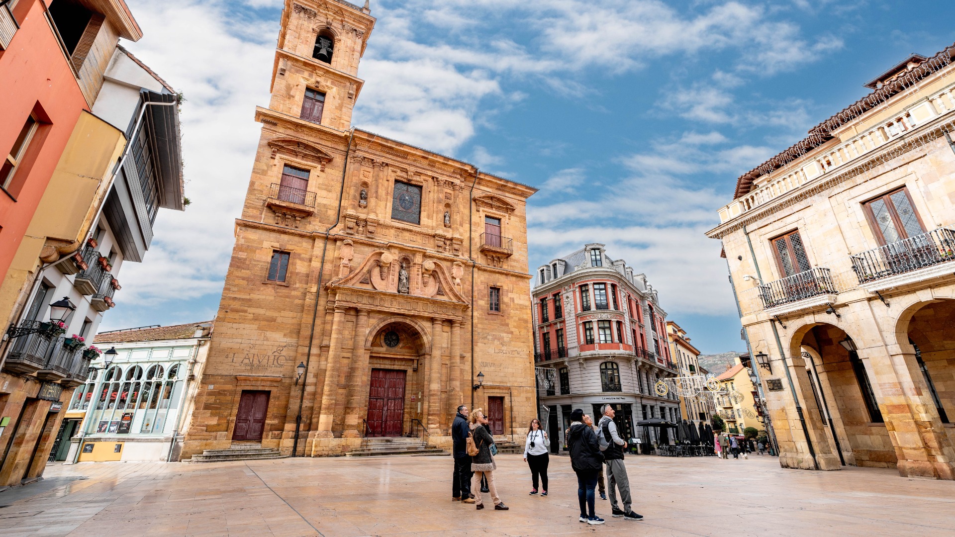 Turistas y guía de buendía frente a la Iglesia de San Isidoro el Real en el casco antiguo de Oviedo