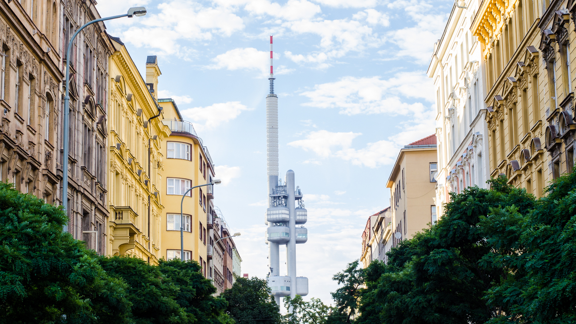 Torre de Televisión Žižkov encajada entre edificios de calles en Praga.