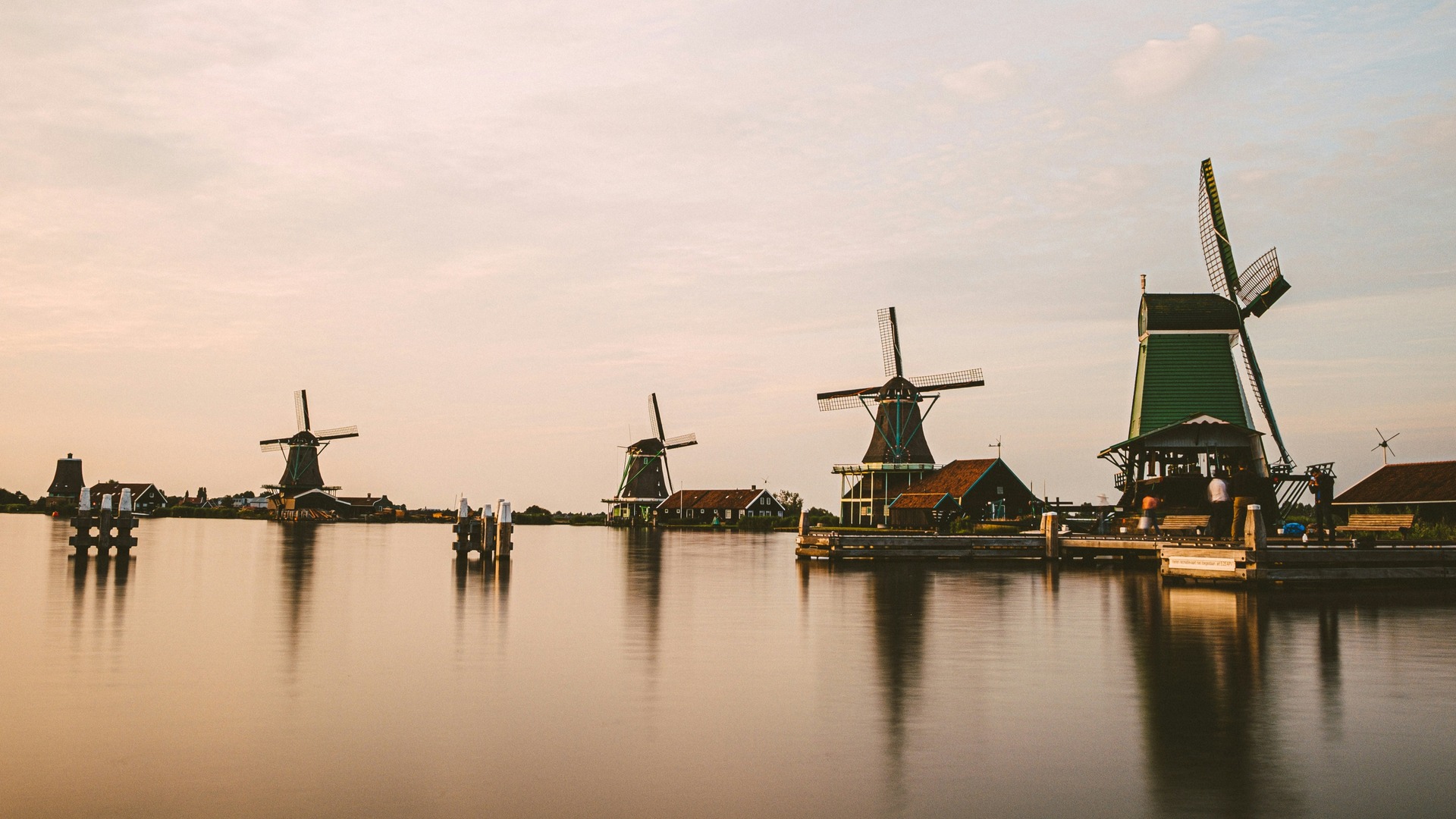 Molinos de viento de Zaanse Schans reflejados en el agua durante el atardecer. 
