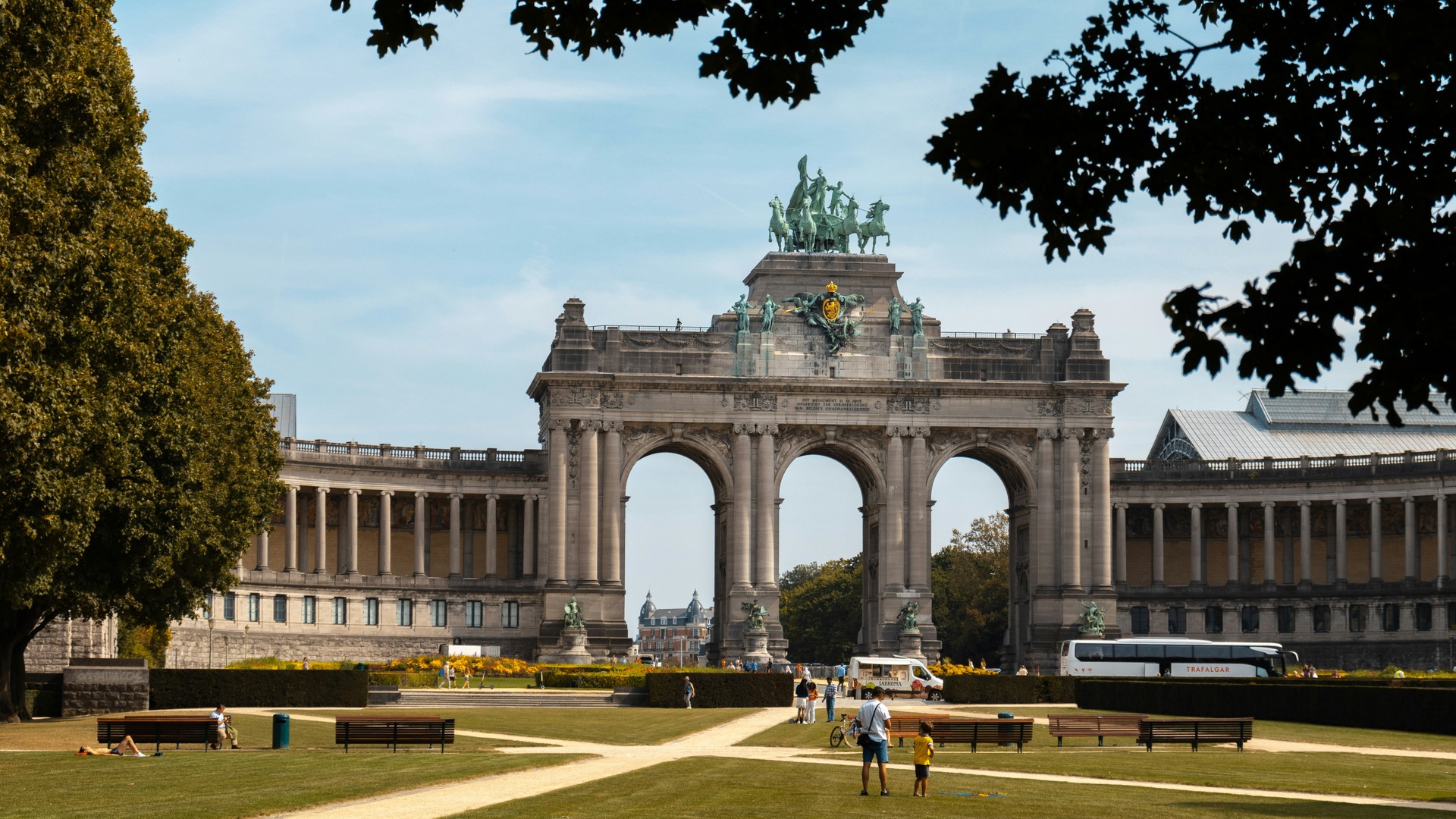 Turistas paseando frente al Arco del Triunfo del Parque del Cincuentenario.