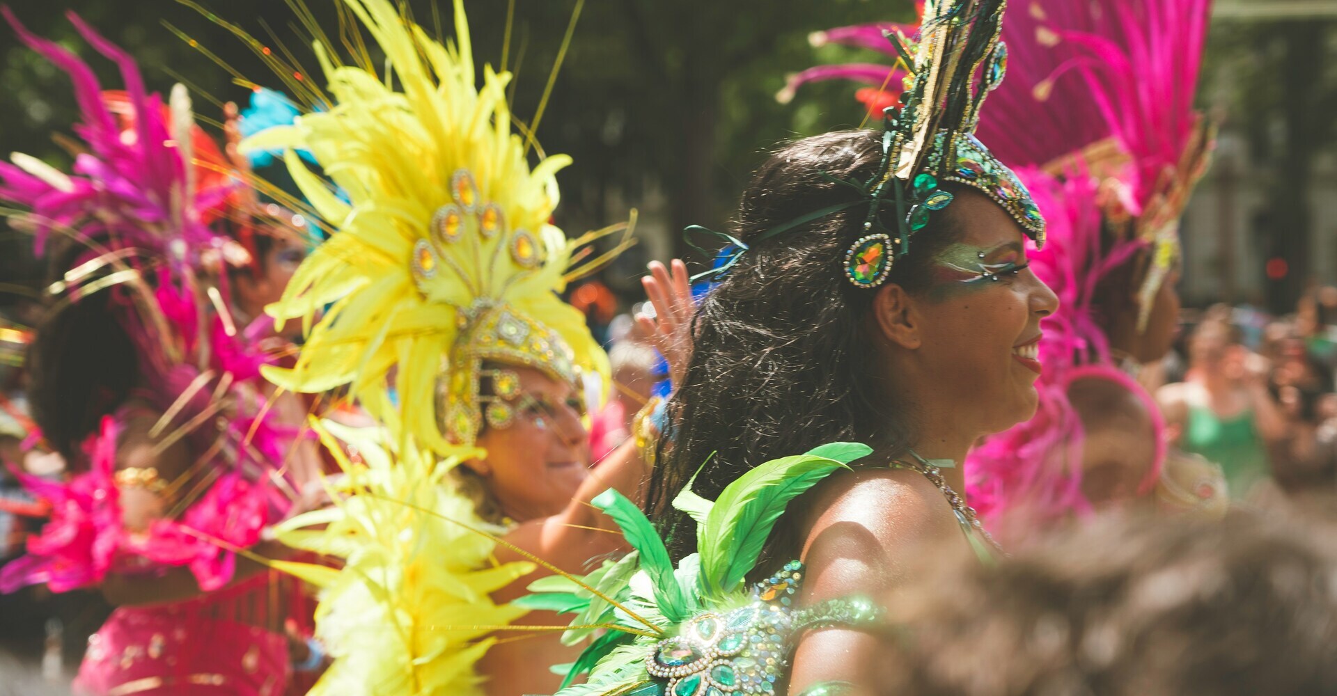 Bailarinas con trajes de plumas coloridas desfilando en el Carnaval de Sitges
