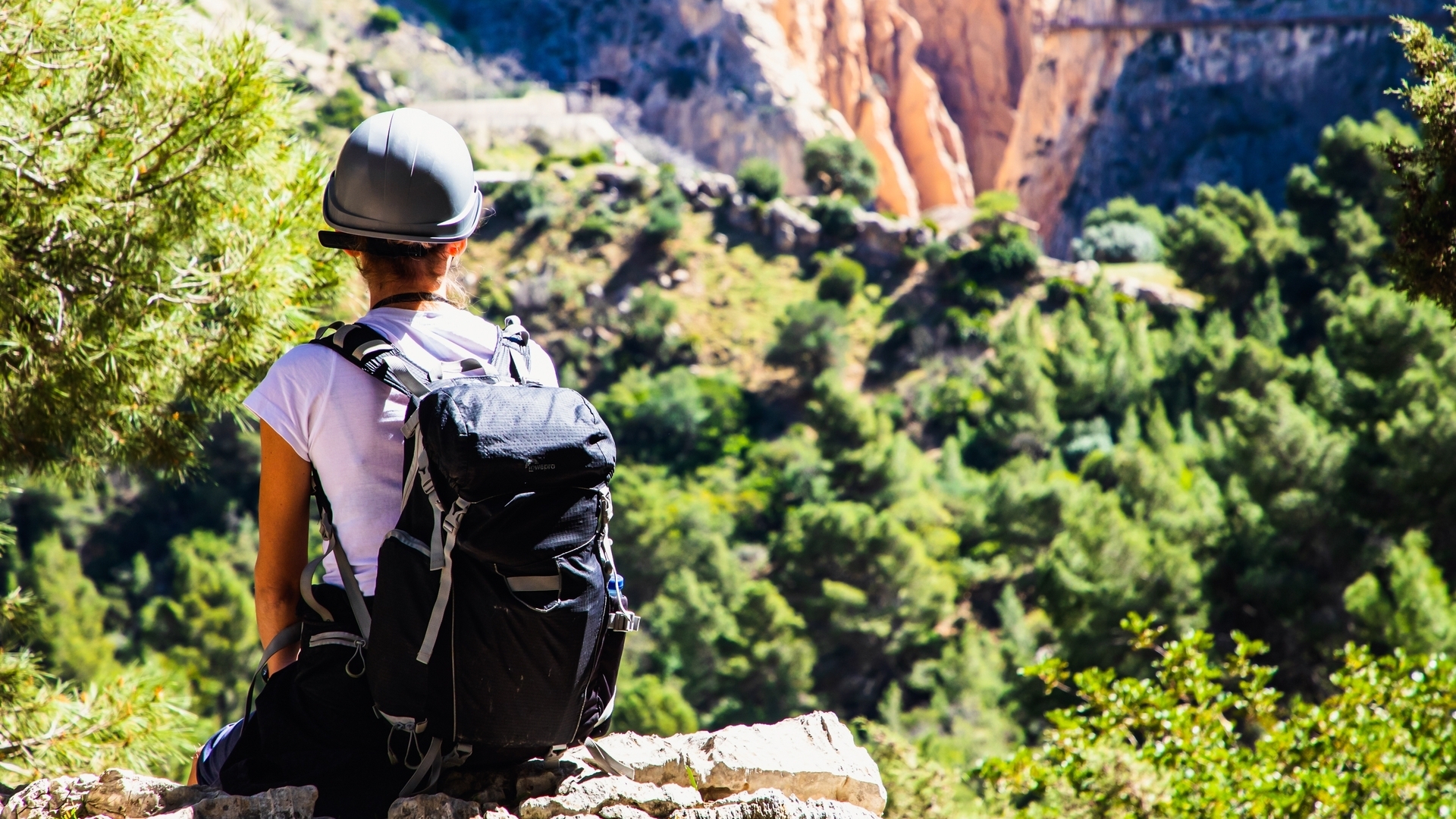 Senderista con mochila y casco contemplando el paisaje del Caminito del Rey
