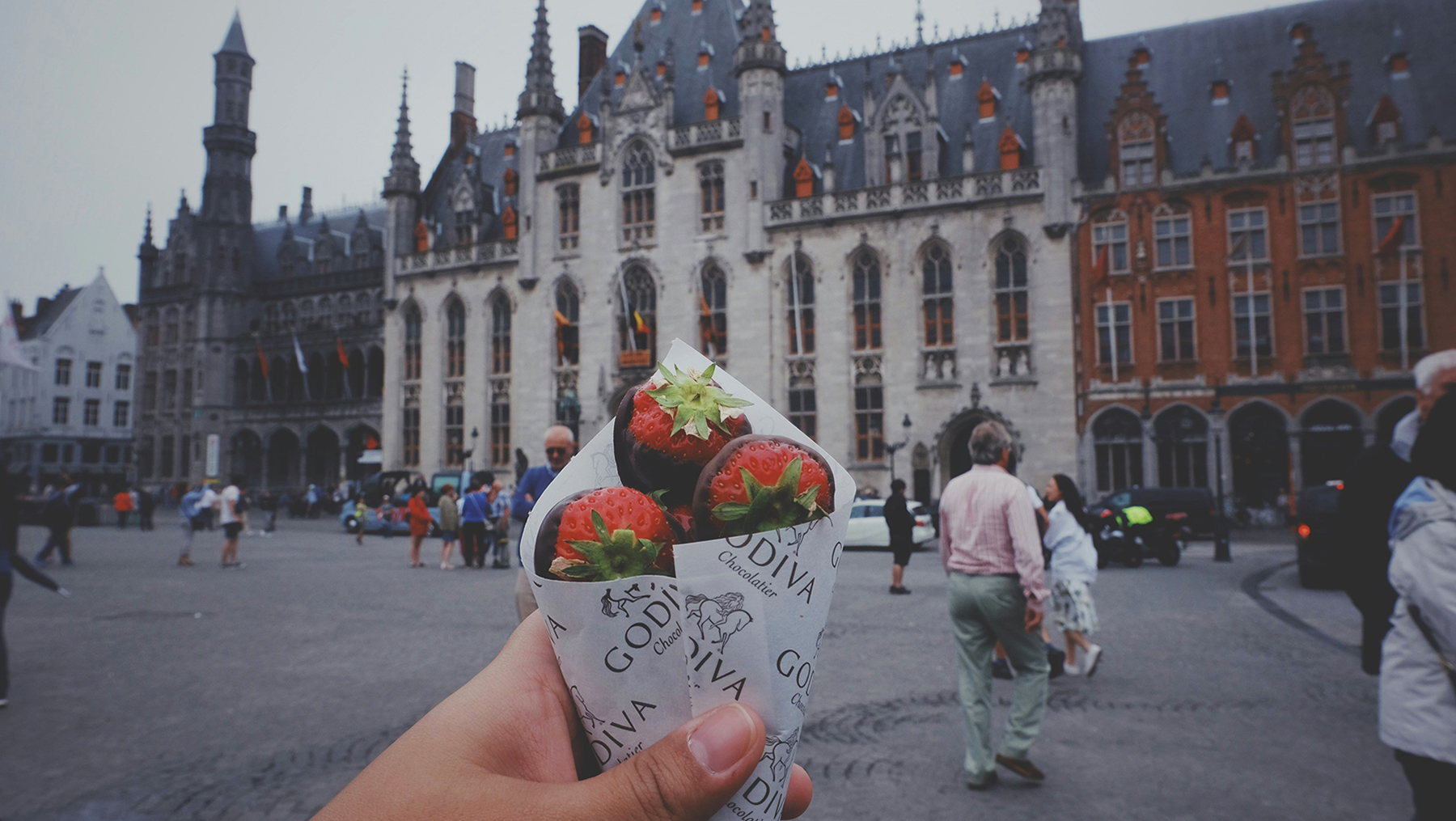 Cono de fresas con chocolate Godiva frente al Ayuntamiento de Brujas, Bélgica