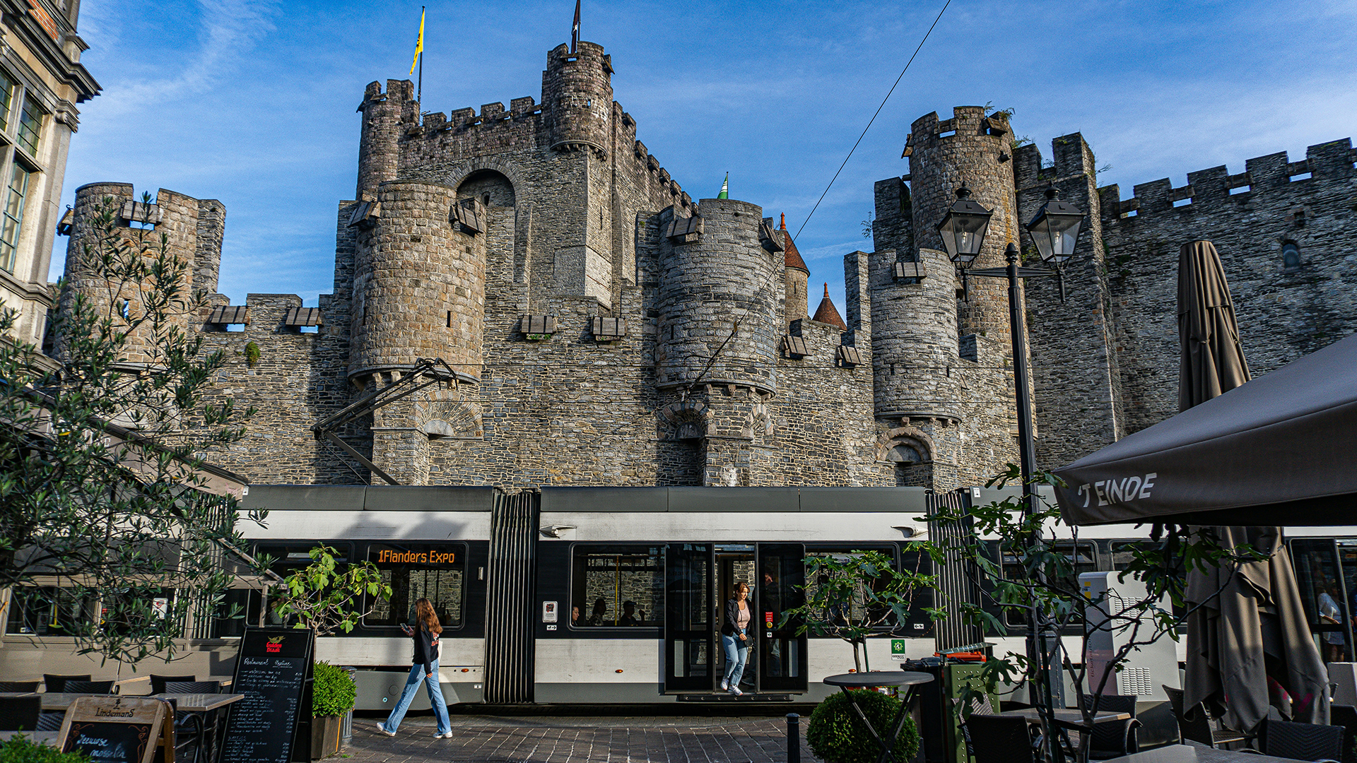 Tranvía moderno frente al castillo Gravensteen en Gante, Bélgica.