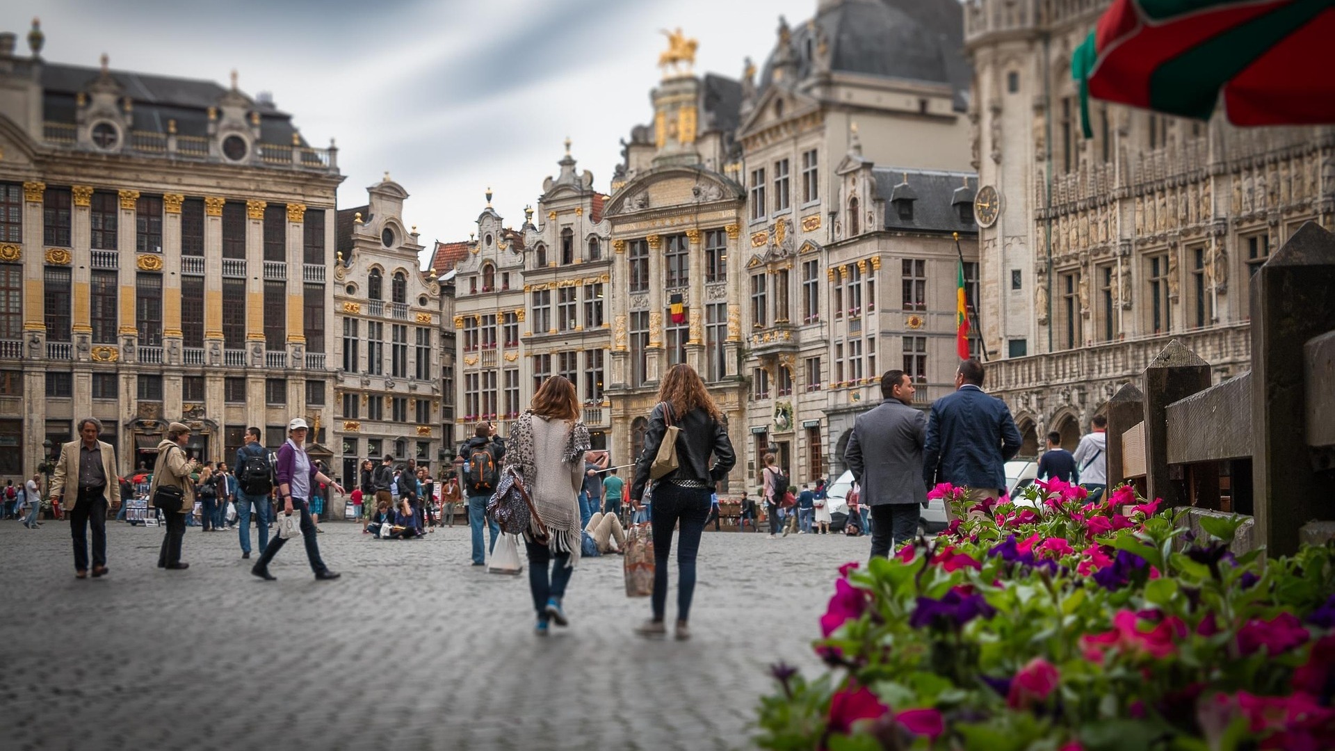 Turistas paseando por la Grand Place de Bruselas rodeada de edificios barrocos.