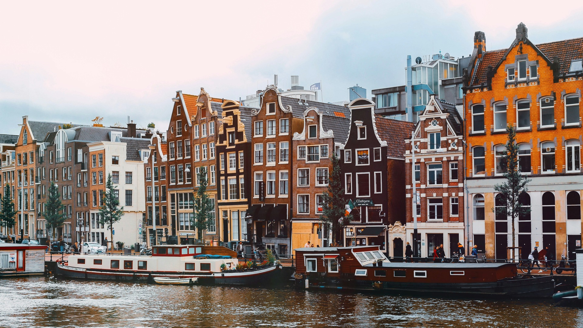 Casas flotantes y fachadas tradicionales junto a un canal en Ámsterdam.