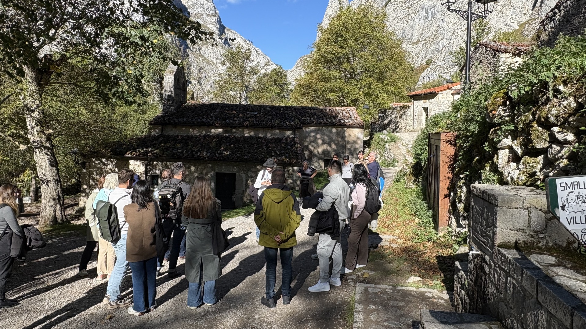 Turistas en una visita guiada de buendía frente a la iglesia de Bulnes, Picos de Europa