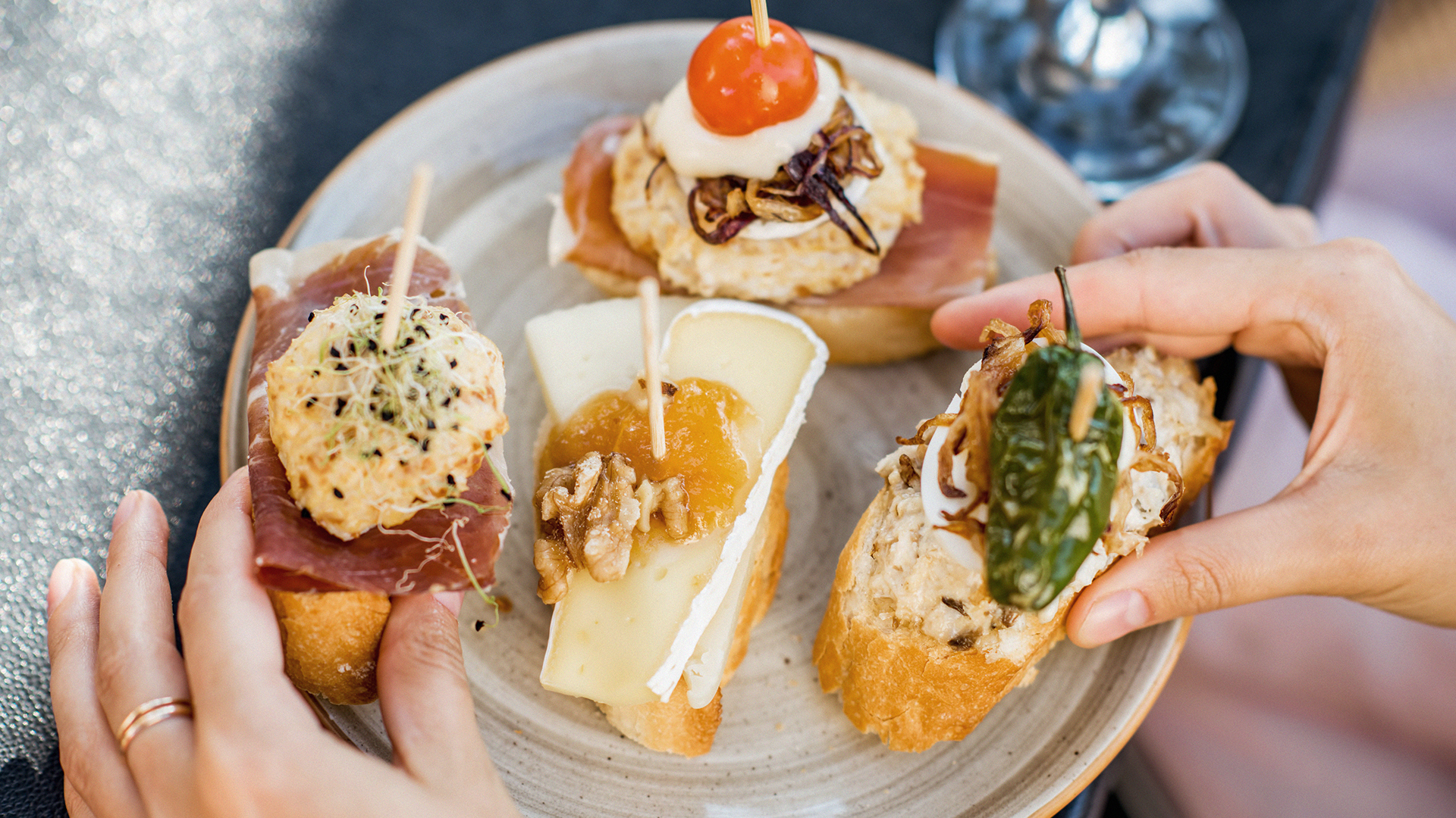 Variedad de pinchos gourmet sobre pan artesano en una terraza de San Sebastián