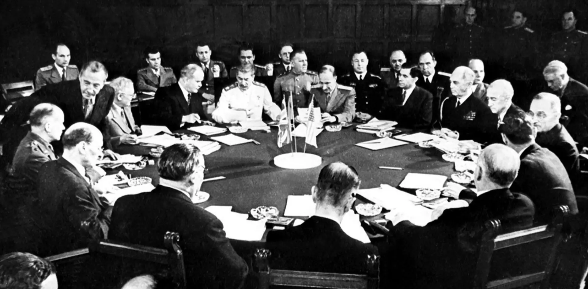 Fotografía histórica de la Conferencia de Potsdam en 1945, con Truman, Stalin y Attlee y sus delegaciones en una mesa redonda.