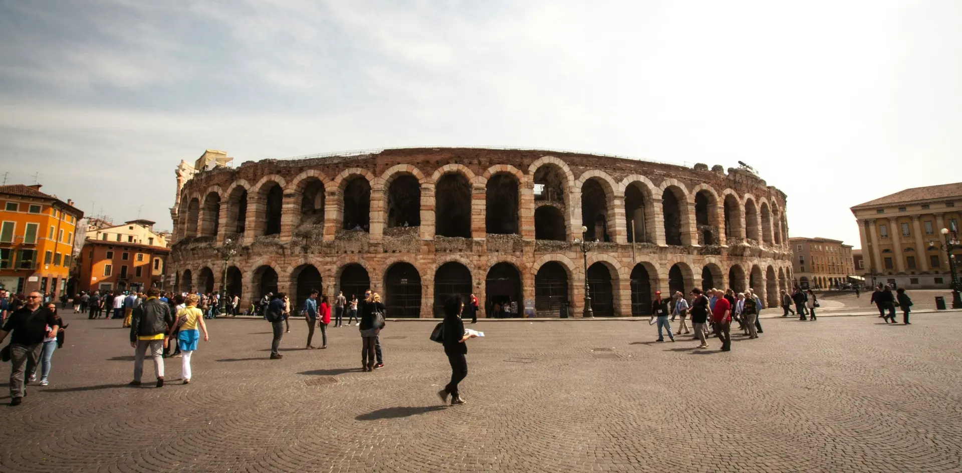 Turistas frente a la Arena de Verona en una plaza soleada