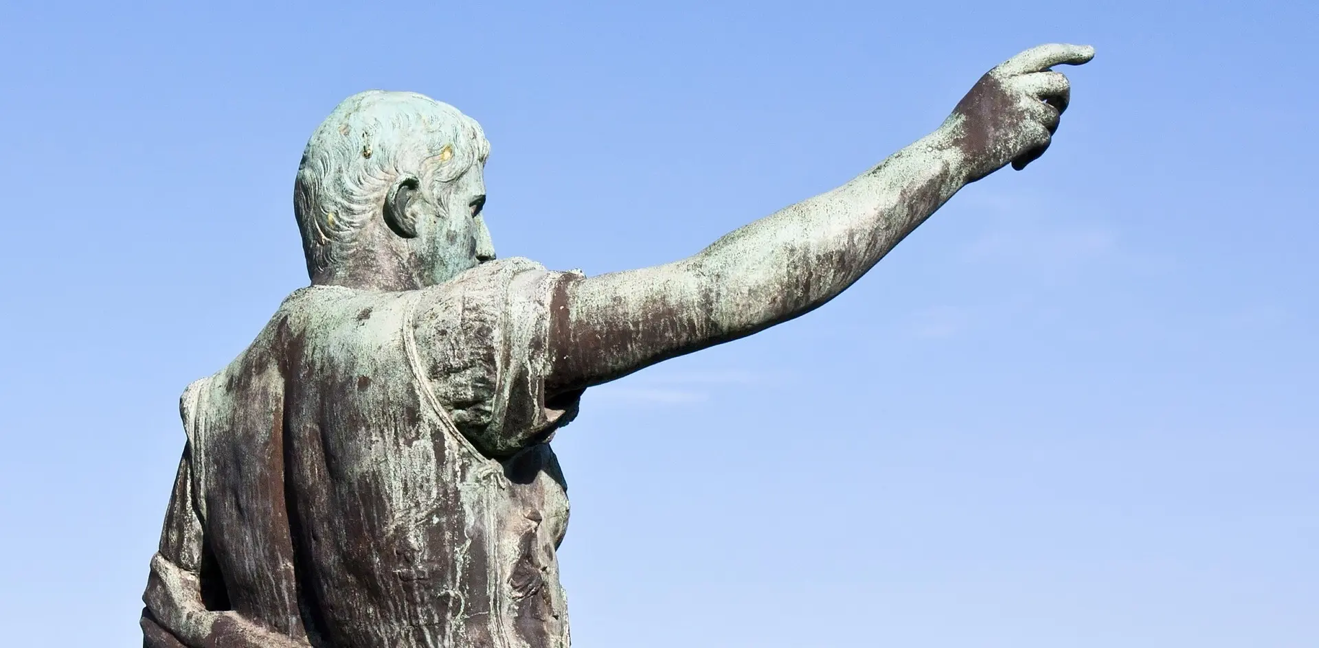 Estatua de bronce de Octavio Augusto señalando al horizonte en Gijón, Asturias.