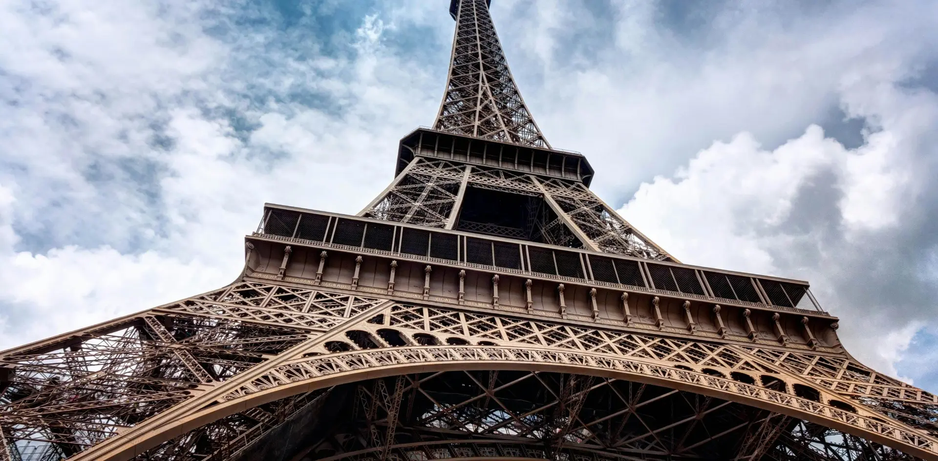 Torre Eiffel vista desde su base hacia el cielo nublado en París, Francia