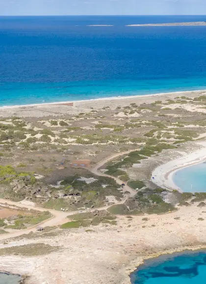 Playa de Formentera, aguas turquesas, arena blanca, veleros, yates, bañistas