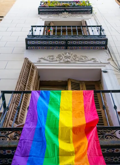 Fachada de un edificio con la bandera que representa los derechos LGTBI.