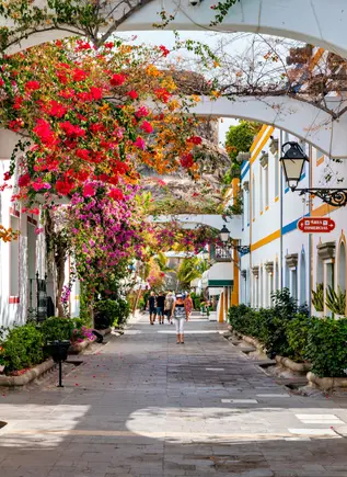 Casas adornadas con flores en una de las calles turísticas del Puerto Magán.