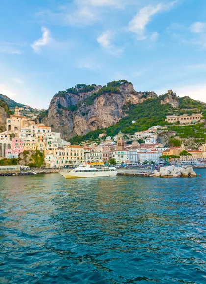 Vista de Capri desde el mar, con los Jardines Augusto, el puerto y una estampa de postal.