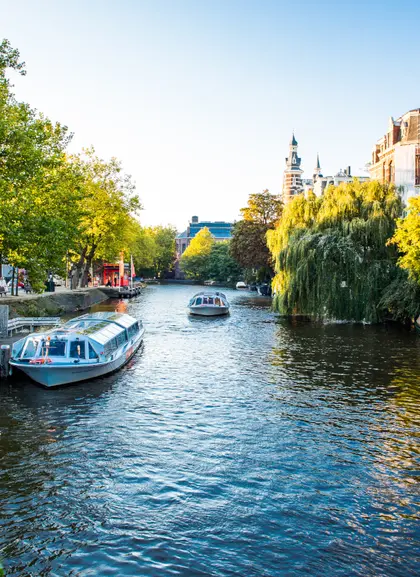 Barcos en los canales de Ámsterdam rodeados de árboles