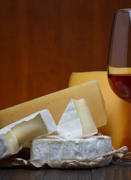 Primer plano de quesos acompañado de vino que harán las delicias de tu paladar.