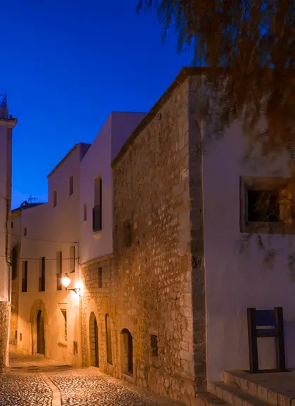 Calles empedradas de Ibiza por la noche, creando un ambiente mágico.