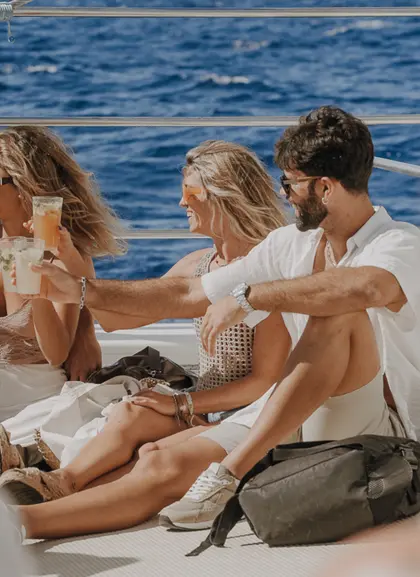 Un grupo de pasajeros disfruta del trayecto mientras el barco se desliza por el agua, con risas, sol y brisa marina.
