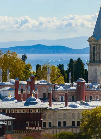 Fachada del Palacio de Topkapi en Estambul, rodeado de jardines y arquitectura otomana clásica.