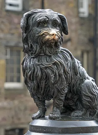 Estatua de Greyfriars Bobby, el famoso perro leal de Edimburgo, frente al cementerio de Greyfriars.